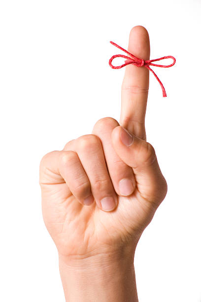 Right hand with reminder string tied to index finger isolated on white